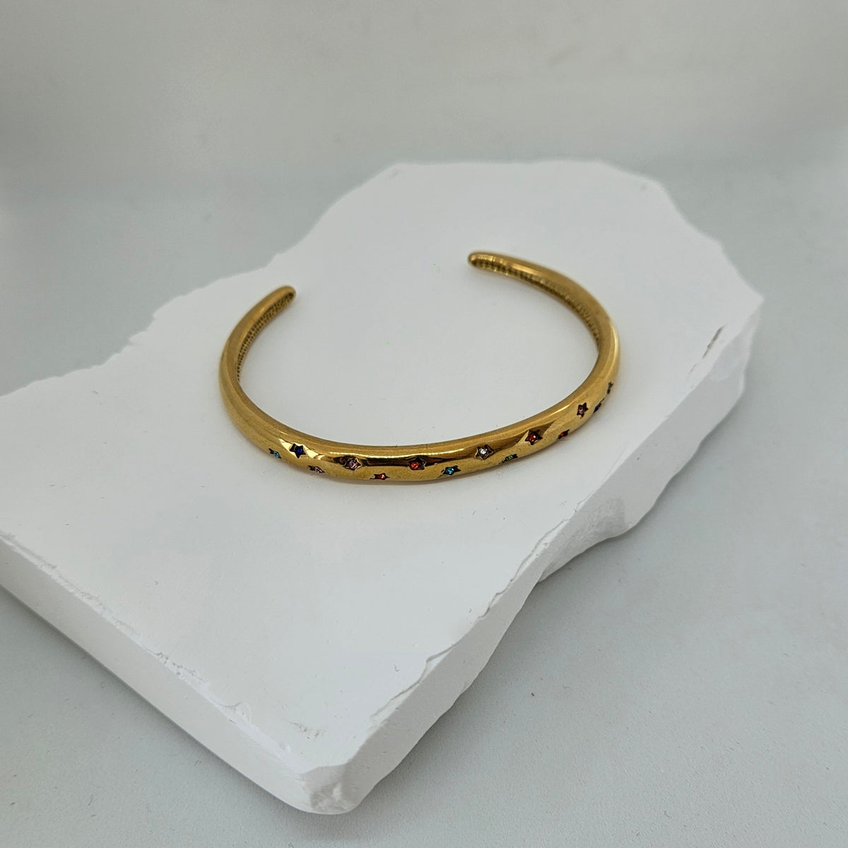 Gold cuff bracelet with colorful stars photo
